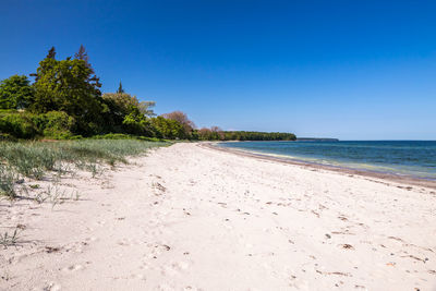 Scenic view of beach against clear blue sky