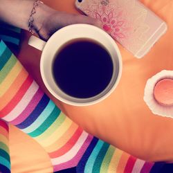 Low section of woman holding black coffee by table