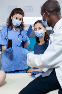 Doctor wearing mask talking with patient