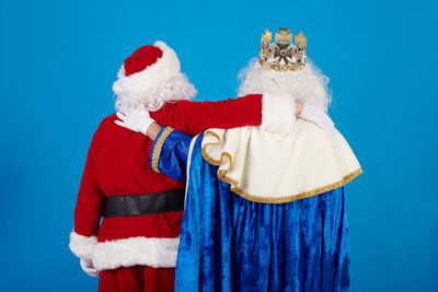 Rear view of woman standing against blue background