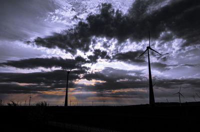 Low angle view of wind turbines at sunset