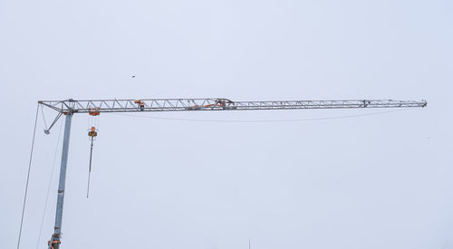 Low angle view of crane against clear sky