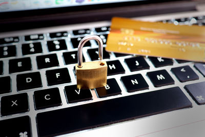 Close-up of padlock and credit card on keyboard