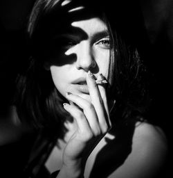 Portrait of young woman smoking cigarette