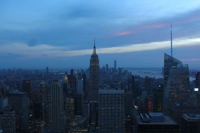 Modern buildings in city against cloudy sky