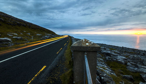 Empty road against cloudy sky