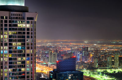 Illuminated buildings in city against sky at night