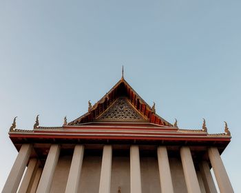 Low angle view of temple against building against clear sky