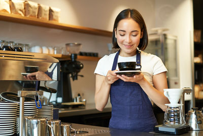 Young woman using mobile phone in cafe