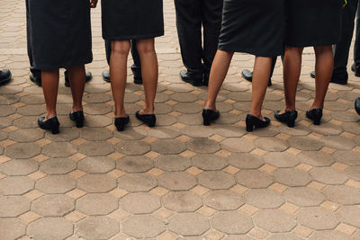 Low section of people standing on tiled floor