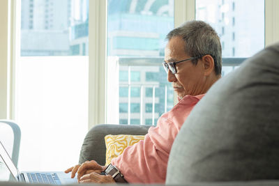 Midsection of man using mobile phone while sitting in office