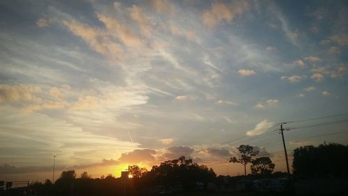 Low angle view of silhouette trees against sky