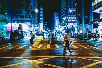 People walking on city street at night