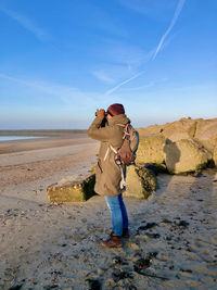 Full length of woman standing on land against sky