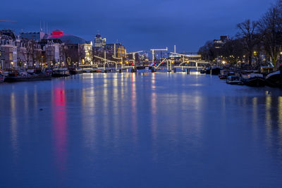 City scenic from amsterdam  with the iluminated thiny bridge in the netherlands at sunset
