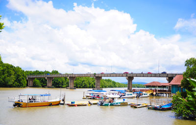 Boats moored in river against sky