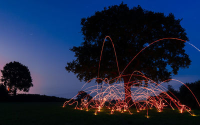 Low angle view of fireworks against sky at night