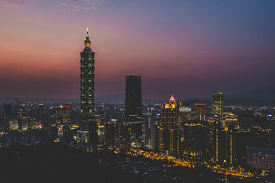 Illuminated buildings against sky at night