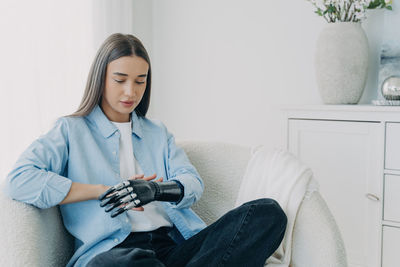 Portrait of young woman using mobile phone at home