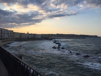 Scenic view of river against sky at sunset