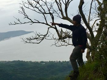 Full length of boy on tree against sky