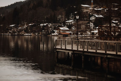 Houses by lake and buildings in city