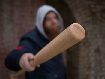 Close-up portrait of baby girl holding wood