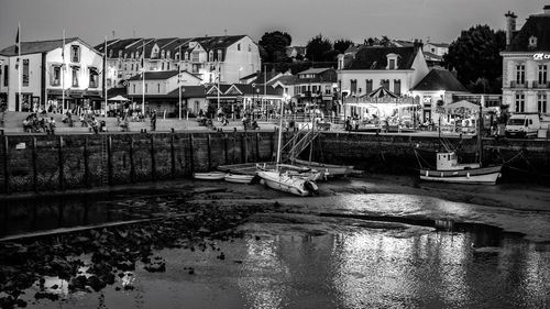 Boats moored at harbor against sky