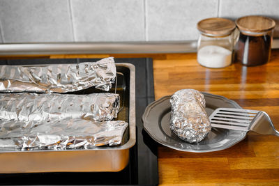 Cooked food in aluminium foil on kitchen counter