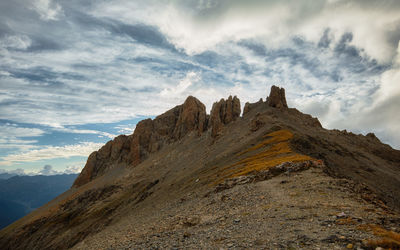 Low angle view of rocky mountains against sky