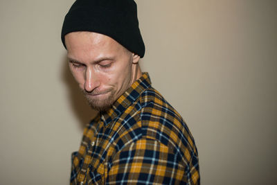Portrait of man wearing hat against gray background