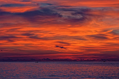 Scenic view of sea against dramatic sky during sunset