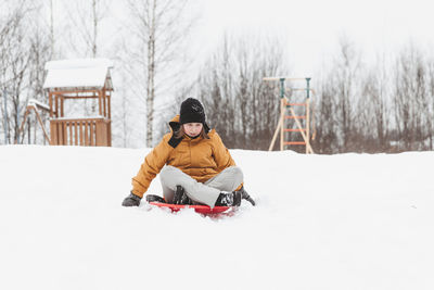 A girl rides down a slide in a winter park, a healthy lifestyle, a sports walk