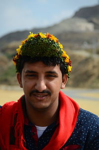 Portrait of young man wearing flowers outdoors