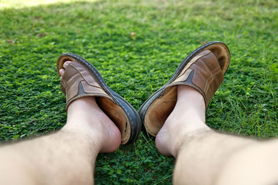 Low section of person relaxing on field