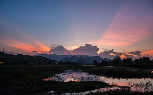 Scenic view of lake against romantic sky at sunset