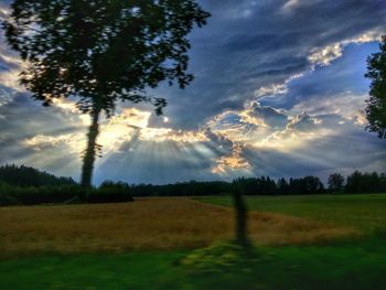 Scenic view of grassy field against cloudy sky