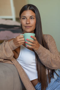 Portrait of a young woman drinking coffee