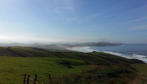 Idyllic shot of landscape and sea against sky