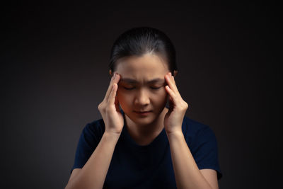 Portrait of a teenage girl against black background