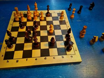 High angle view of chess board on blue table