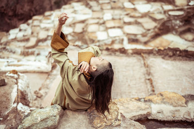 Androgynous mixed race dancer dances in salt farm on mountain side