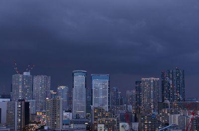 Illuminated buildings in city against sky