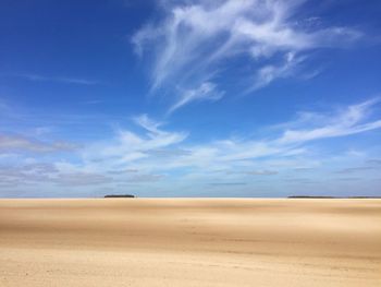 Scenic view of desert against blue sky