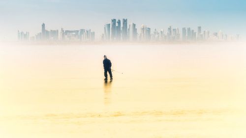 Full length of man ice-skating in city during winter