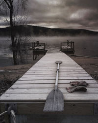 Wooden jetty on pier over lake against sky
