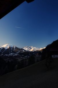 Scenic view of snowcapped mountains against clear blue sky