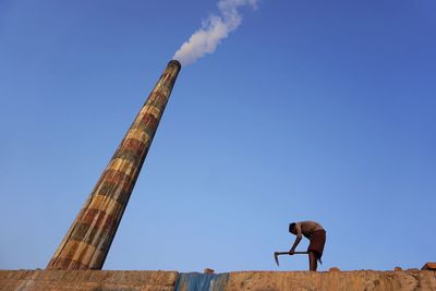 Low angle view of man against blue sky