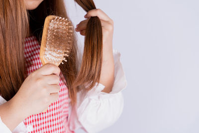 Midsection of woman holding ice cream against white background