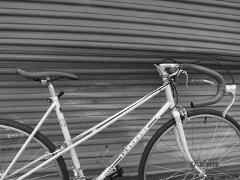 Close-up of bicycle parked against brick wall